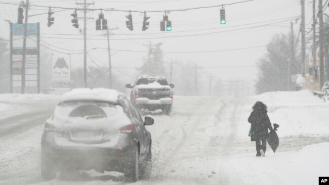 In this photo, heavy snow falls as a person walks along U.S. Route 42 in Florence, Ky., Monday, Jan. 6, 2025. (AP Photo/Carolyn Kaster, File)