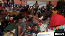 Migrantes haitianos que buscan refugio en EE. UU. descansan fuera del albergue Casa INDI mientras esperan ser procesados por la Comisión Mexicana de Ayuda a Refugiados (COMAR), en Monterrey, México, el 4 de octubre de 2021. 