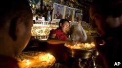 西藏日喀则扎什伦布寺的僧侣2019年7月19日在点亮寺庙松油。