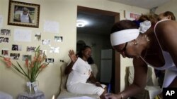 Belkis Jorrin, of Cuban dissident group Ladies in White, signs a condolence book for late dissident Wilman Villar in Havana, Cuba, Friday, Jan. 20, 2012.