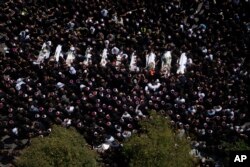 Mourners from the Druze minority surround the bodies of some of the 12 children and teens killed in a rocket strike at a soccer field, during their funeral, in the village of Majdal Shams, in the Israeli-annexed Golan Heights, July 28, 2024.