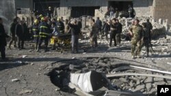 Iraqi civilians and security forces inspect a crater caused by a car bomb attack in Kirkuk, 180 miles (290 kilometers) north of Baghdad, Iraq, February 3, 2013. 