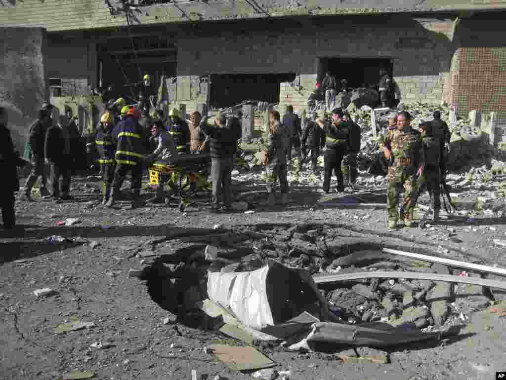 2013年2月3日，伊拉克平民和安全部队在巴格达以北290公里远的城市基尔库克检查地面上一个被汽车炸弹爆炸炸开的弹坑。