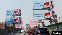 FILE - Cars move along the '6th October Bridge' lined with banners of Egyptian President Abdel Fattah el-Sissi, in Cairo, Egypt, Oct. 2, 2019.