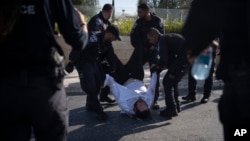 ARCHIVO - Agentes de policía israelíes se llevan a un hombre judío ultraortodoxo de la calle durante una protesta contra el reclutamiento militar en Jerusalén, el 2 de junio de 2024