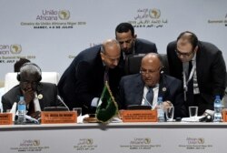 FILE - Egyptian Foreign Minister Sameh Shoukry, center, reads a document at an AU meeting in Niamey, Niger, July 5, 2019, where the African Continental Free Trade Area was launched. CEMAC, a similar trade group, has had trouble progressing.