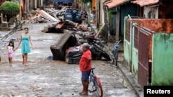 FILE - Residents walk on a street which was flooded by the Poti river in Teresina in the northeastern Brazilian state of Piaui, May 8, 2009. 