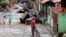 FILE - Residents walk on a street which was flooded by the Poti river in Teresina in the northeastern Brazilian state of Piaui, May 8, 2009. 