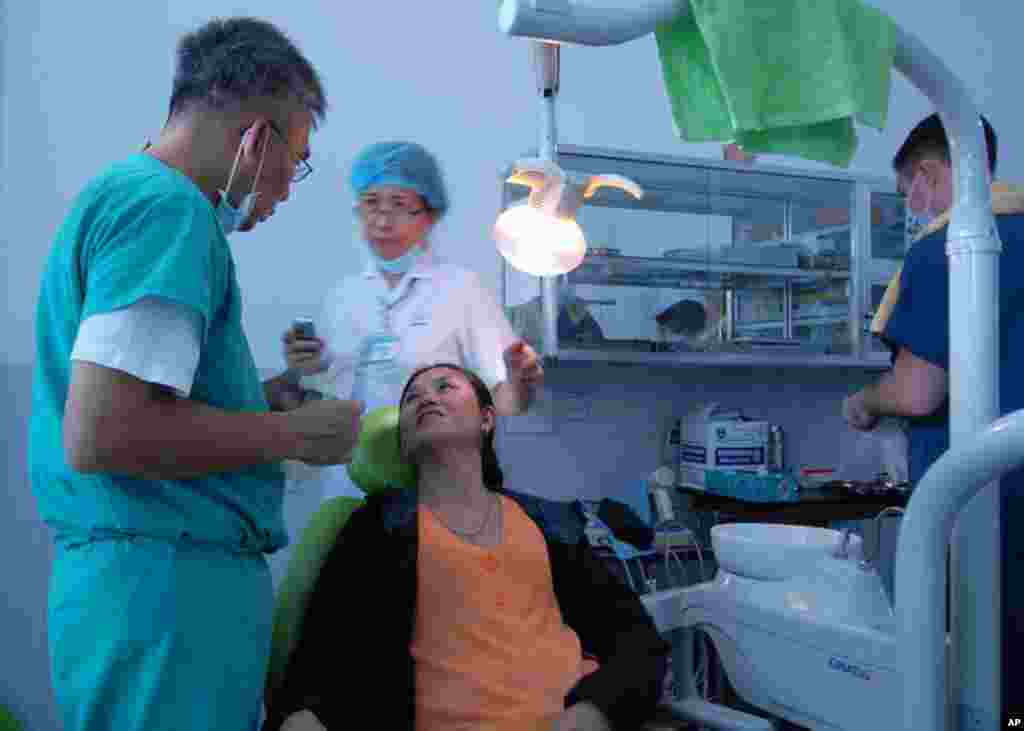 峴港 (7月16日) 美國海軍一名牙醫在診斷前與病人交談。 美國海軍在峴港一所醫院參加醫務交流活動。