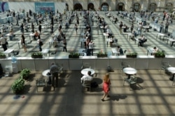 People wait in line for a COVID-19 vaccine at a vaccination center in Gostinny Dvor, a huge exhibition place in Moscow, July 6, 2021.