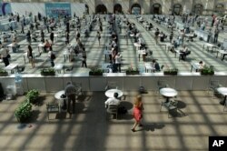 People wait in line for a COVID-19 vaccine at a vaccination center in Gostinny Dvor, a huge exhibition place in Moscow, July 6, 2021.