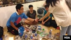 Student volunteers offer a free phone charging service at “Charging Corner” inside Hong Kong’s occupied central business district. The students have adapted a multi-USB powerboard, and can charge up to 80 telephones from one electric socket, Oct. 8, 2014. (Ivan Broadhead/VOA)