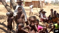 FILE - Children shelter from the sun in Ankilimarovahatsy, Madagascar, a village in the far south of the island where most children are acutely malnourished, Nov. 9, 2020. 