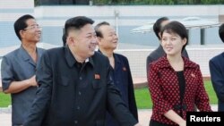 အမည်မသိ အမျိုးသမီးတဥိးနှင့် အတူတွေ့ရသည့် မြောက်ကိုရီးယားခေါင်းဆောင် ကင်မ် ဂျုံအွန်း။ ဇူလိုင် ၂၅၊ ၂၀၁၂။