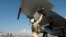 In this photo taken on Oct. 5, 2015, a Russian pilot fixes an air-to-air missile at his Su-30 jet fighter before a take off at Hmeimim airbase in Syria.