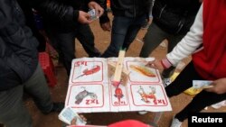 Para warga meletakkan uang dalam perjudian ilegal di sebuah desa di Hanoi, 12 Februari 2014. (Foto:dok)