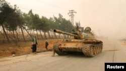 A tank belonging to rebel fighters drives in Dahiyat al-Assad west Aleppo city, Syria Oct. 28, 2016. 