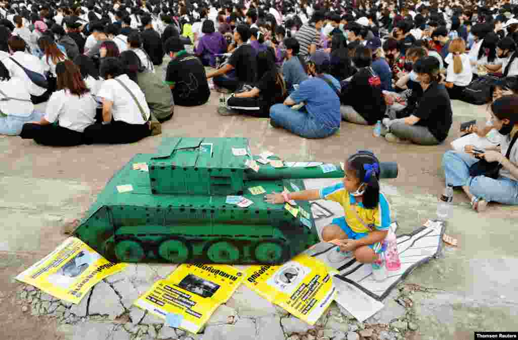 태국 킹몽꿋 공과대학 학생들의 민주화 시위 현장에서 한 아이가 종이 탱크 앞에서 놀고 있다. 