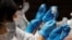 Health care workers prepare doses of the Moderna coronavirus vaccine before administering them to staffers of Japan's supermarket group Aeon at the company's shopping mall in Chiba, Japan, June 21, 2021. 