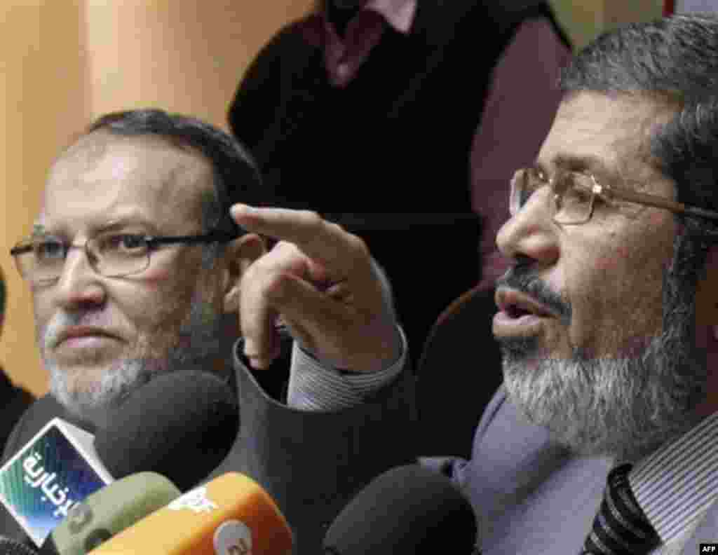 Senior members of Egypt's Muslim Brotherhood Mohamed Morsi, right, and Essam el-Erian hold a press conference on the latest situation in Egypt in Cairo, Egypt, Wednesday, Feb. 9, 2011. (AP Photo/ Mohammed Abou Zaid)