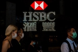 Pedestrians walk past a HSBC logo in Hong Kong, Sept. 21, 2020.