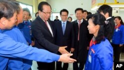 한국 국회가 개성공단 첫 현지 시찰을 실시한 30일 외교통일위 안홍준 위원장이 개성공단의 북한 노동자에게 악수를 청하고 있다.