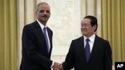 U.S. Attorney General Eric Holder, left, shakes hand with Chinese Politburo Standing Committee member Zhou Yongkang during a meeting at the Great Hall of the People in Beijing, China, Wednesday, Oct. 20, 2010. (AP Photo/Ng Han Guan, Pool)