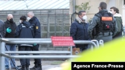 Police confer near the site of a shooting on the campus of the University in Heidelberg, southwestern Germany, after an attack by a lone gunman, Jan. 24, 2022.