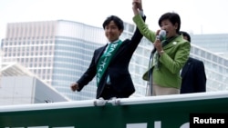 FILE : Tokyo Governor and head of Tokyo Citizens First party Yuriko Koike (R) delivers a speech to voters atop of a campaign van as election campaign officially kicks off for Tokyo Metropolitan Assembly election, on the street in Tokyo, June 23, 2017. 