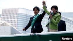 ARSIP – Gubernur Tokyo dan ketua partai Tokyo Citizens First, Yuriko Koike (Kanan) berpidato kepada para pemilih di atas mobil kampanye setelah kampanye pemilu secara resmi diluncurkan di Tokyo, 23 Juni 2017 (foto: REUTERS/Issei Kato/Foto Arsip)