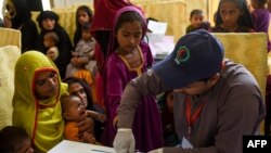 FILE - A Pakistani paramedic takes a blood sample from a girl for a HIV test at a state-run hospital in Rato Dero in the district of Larkana of the southern Sindh province, May 9, 2019. 