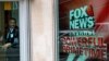 FILE - This April 19, 2017, photo shows a security guard looking out of the News Corporation headquarters in New York. Fox News on March 1, 2024, criticized a federal court decision holding one of its former journalists in civil contempt.