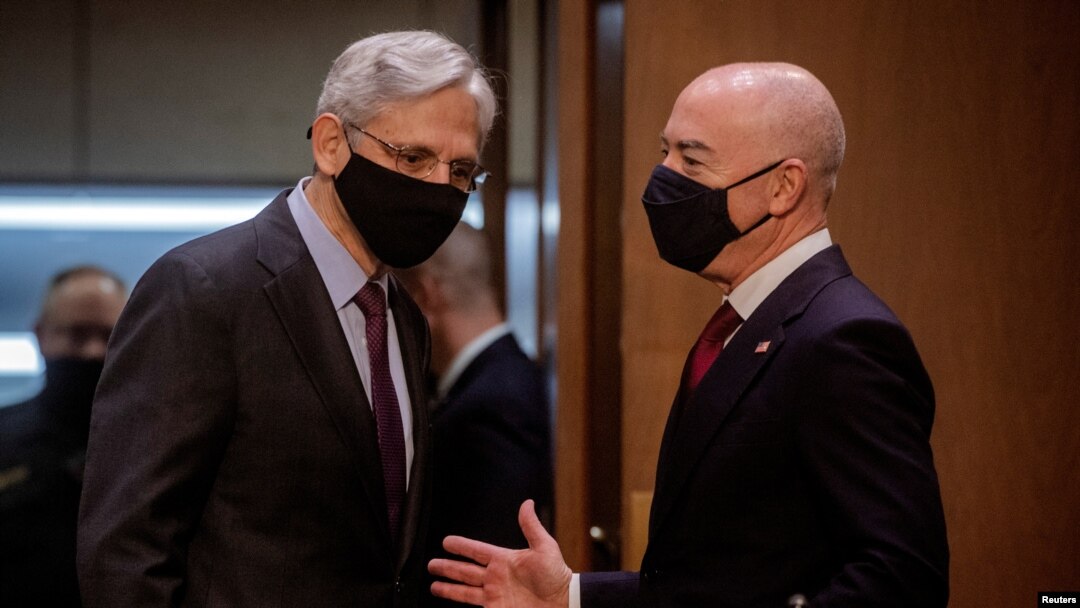 Attorney General Merrick Garland speaks with Homeland Security Secretary Alejandro Mayorkas as they arrive for a hearing on "Domestic Violent Extremism in America." before the Senate Appropriations Committee on Capitol Hill in Washington, May 12, 2021.