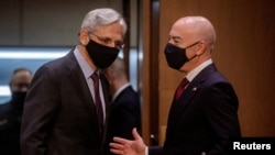 Attorney General Merrick Garland speaks with Homeland Security Secretary Alejandro Mayorkas as they arrive for a hearing on "Domestic Violent Extremism in America." before the Senate Appropriations Committee on Capitol Hill in Washington, May 12, 2021.