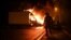 A French anti riot police officer walk past a burning truck in Nantes, western France on early July 1, 2023, four days after a 17-year-old man was killed by police in Nanterre, a western suburb of Paris.