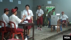 TPS bertema unik di mana panitia berseragam Sekolah Dasar di TPS 16 Gandekan, Solo hari Rabu 27/6 (Foto: VOA/Yudha S.). 