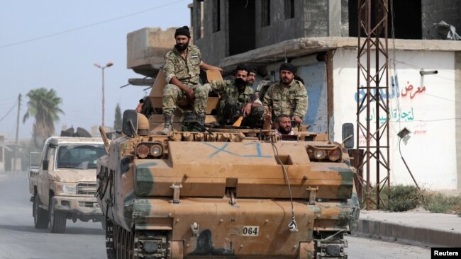 土耳其支持的叙利亚反政府武装驶过边境城镇泰勒艾卜耶德。(2019年10月14日)