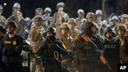 Police and Missouri National Guardsmen stand guard as protesters gather in front of Ferguson Police Department in Ferguson, Nov. 28, 2014.