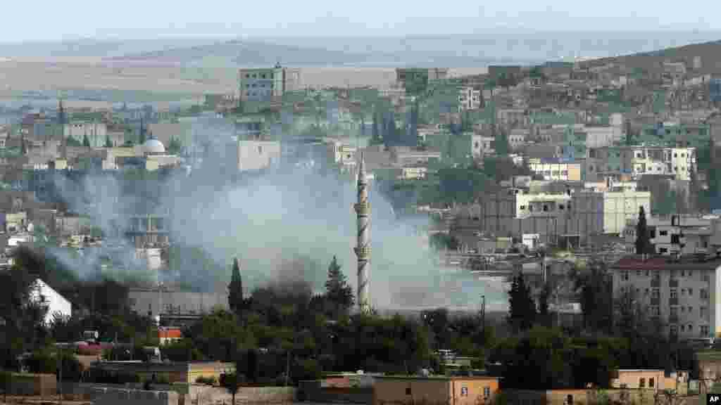 Smoke from a mortar rises in Kobani, Syria while fighting continued between Syrian Kurds and the militants of Islamic State group, as seen from Mursitpinar on the outskirts of Suruc, at the Turkey-Syria border, Oct. 18, 2014. 