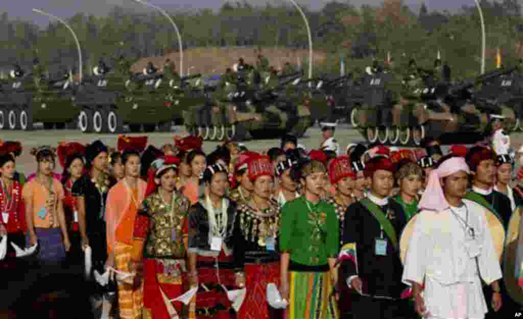 Myanmar people dressed in different ethnic attire march in the foreground of military-tanks during a ceremony to mark Myanmar's 67th anniversary of Independence Day in Naypyitaw, Myanmar, Sunday, Jan. 4, 2015. (AP Photo/Gemunu Amarasinghe)