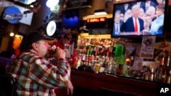 Jeff Dull watches as President Donald Trump is sworn in during a live broadcast of the inauguration at the Sawmill Saloon in Prairie du Chien, Wis., Jan. 20, 2017.