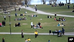 FILE - People visit the Raslambshovsparken Park in Stockholm, Sweden, April 18, 2020. Swedish authorities have allowed a large amount of personal freedom to continue during the pandemic, unlike most other European countries. 