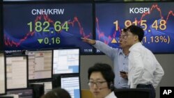 Corredores de la bolsa en Seúl, Corea del Sur, analizan los datos del mercado.