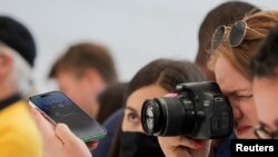 A guest uses a camera to take photos of the new iPhone 14 at an Apple event at their headquarters in Cupertino, California, U.S. September 7, 2022. REUTERS/Carlos Barria