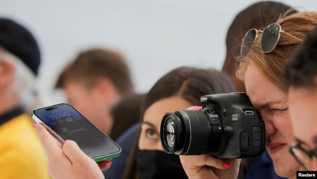 A guest uses a camera to take photos of the new iPhone 14 at an Apple event at their headquarters in Cupertino, California, U.S. September 7, 2022. REUTERS/Carlos Barria