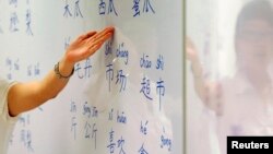 An instructor points out mandarin characters on a whiteboard at a night class for people learning mandarin as a second language in Singapore Sept. 1, 2009.