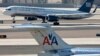 FILE - A U.S. Airways jet passes an American Airlines jet at Sky Harbor International Airport in Phoenix, Arizona, Feb. 14, 2013. 