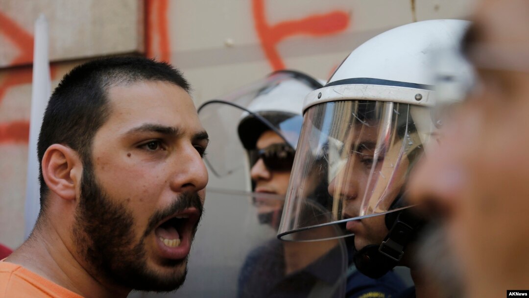 Član radničkog sindikata PAME raspravlja se sa policijom na protestu protiv mera štednje u centru Atine, 3. jula 2015. 