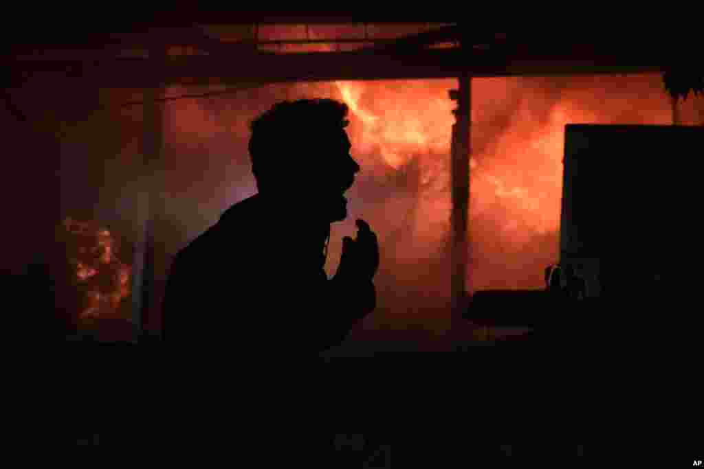 A man screams in front a fire erupting inside a computer shop hit during an Israeli airstrike in central Beirut, Lebanon.