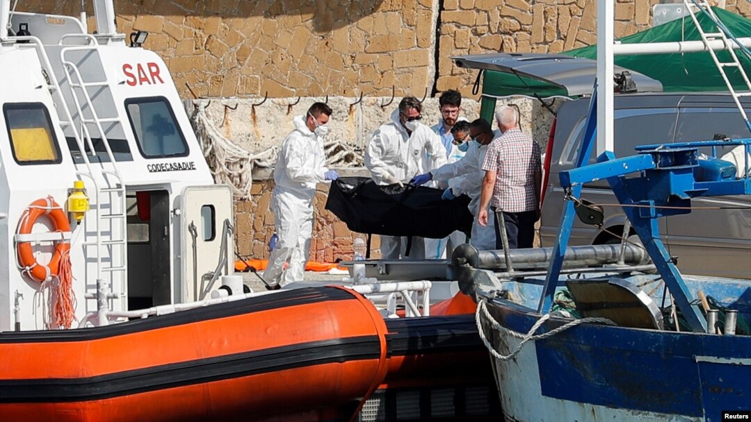 Petugas layanan darurat membawa jenazah korban kapal migran yang terbakar di lepas pantai Crotone, ke dermaga Le Castella , Italia, 30 Agustus 2020.